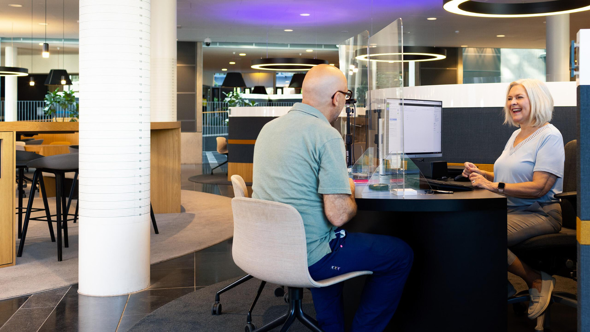 A city service employee helping a resident at a front desk